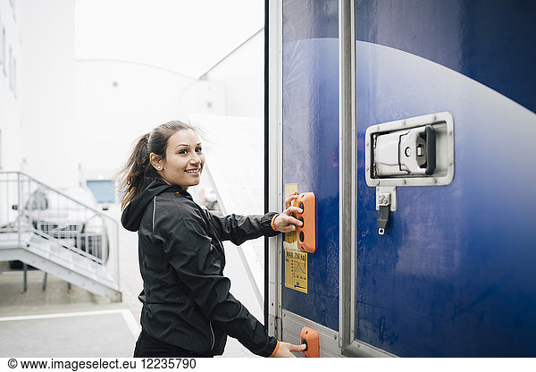 Smiling woman pushing buttons on delivery van