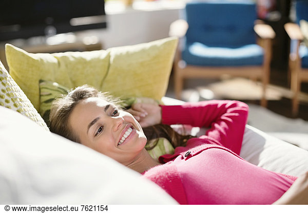 Smiling woman relaxing on sofa