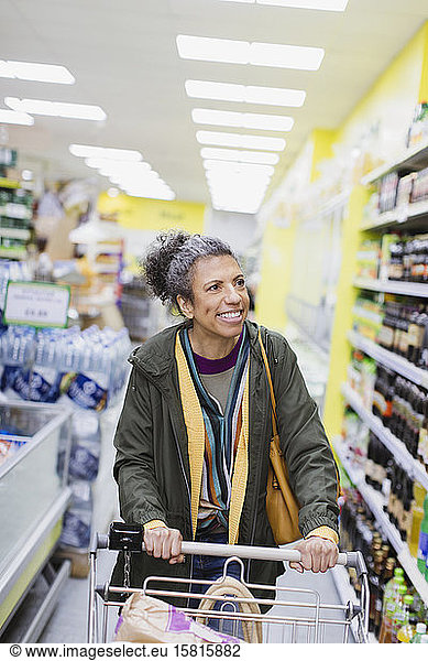 Smiling woman shopping in supermarket