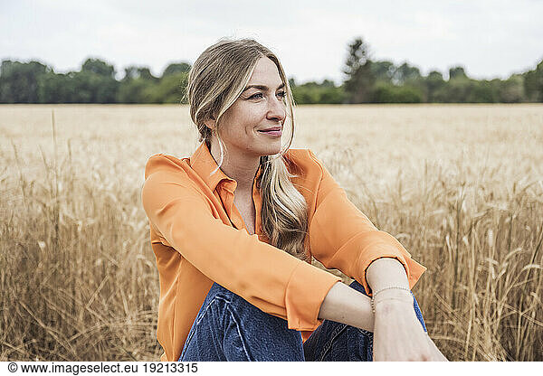 Smiling woman sitting at field