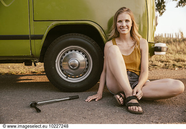 Smiling woman sitting next to a torque wrench at van