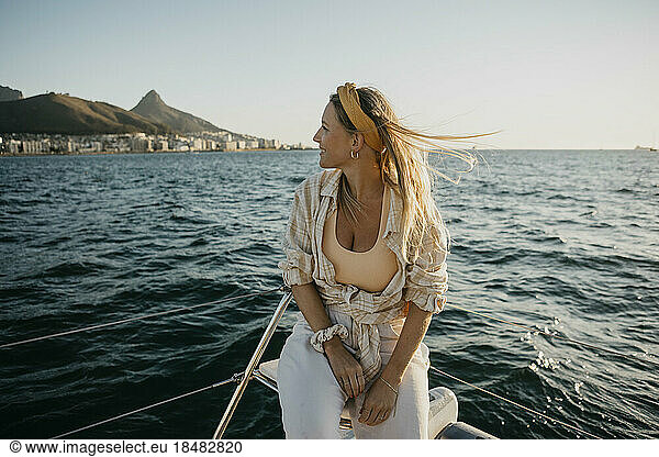 Smiling woman sitting on boat in sea at weekend
