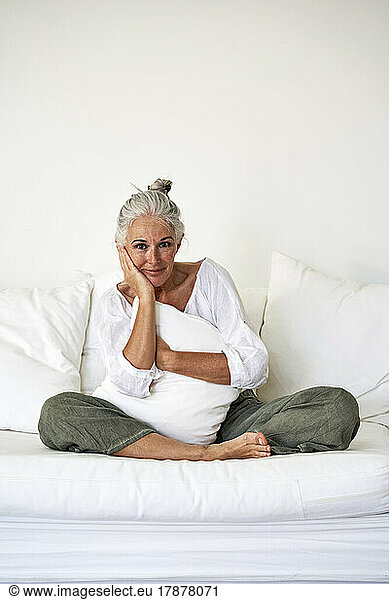 Smiling woman sitting on couch at home