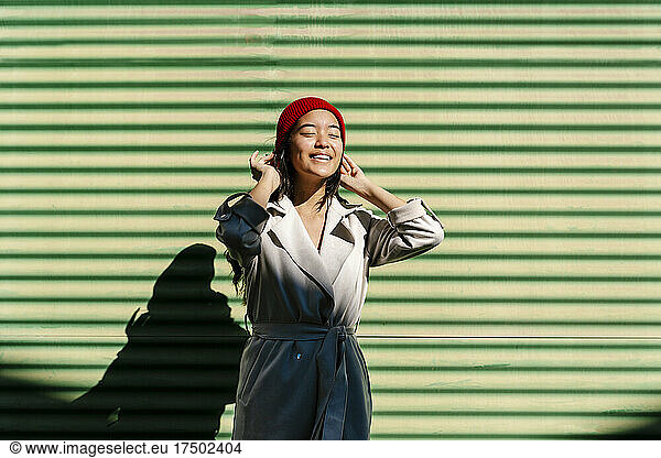 Smiling woman standing in front of green wall
