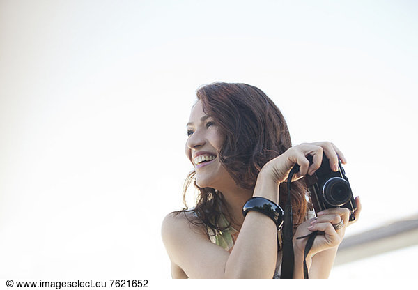 Smiling woman taking pictures outdoors