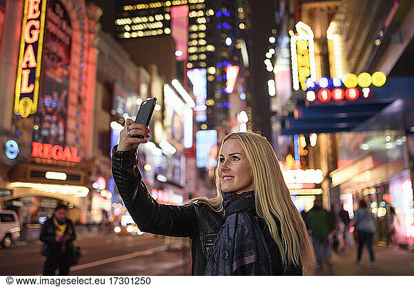 Smiling woman taking selfie in famous city center
