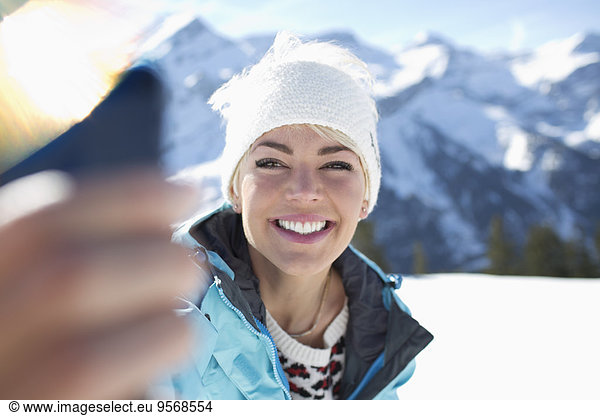 Smiling woman taking selfie in snow