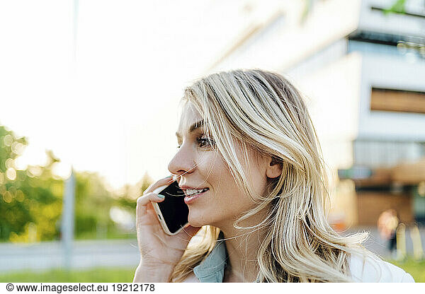 Smiling woman talking on smart phone outdoors