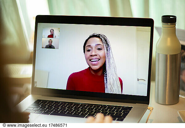 Smiling woman video conferencing on laptop screen