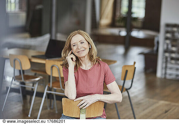 Smiling woman wearing wireless in-ear headphones listening music at home