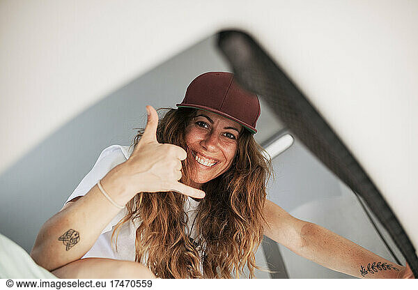 Smiling woman with brown hair gesturing in camper van