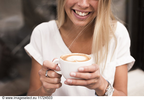 Smiling woman with cappuccino