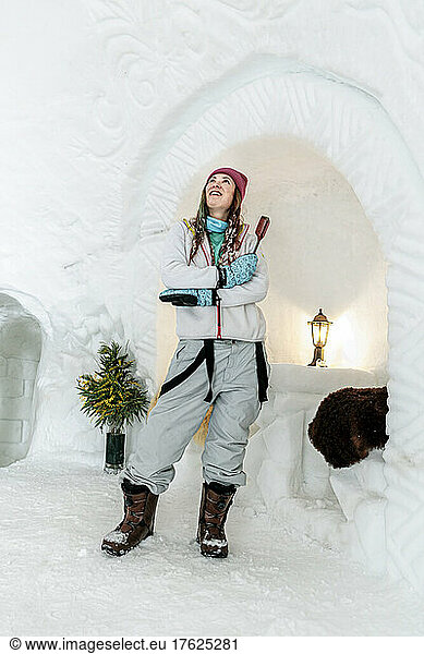 Smiling woman with carving tool standing in igloo