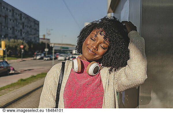 Smiling woman with eyes closed on sunny day