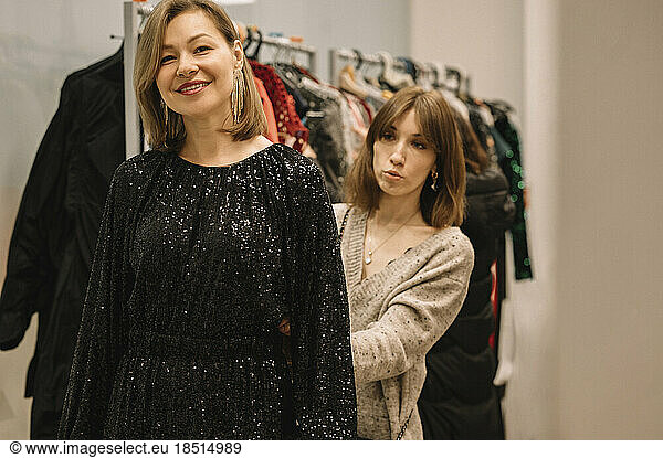 Smiling woman with friend shopping in store