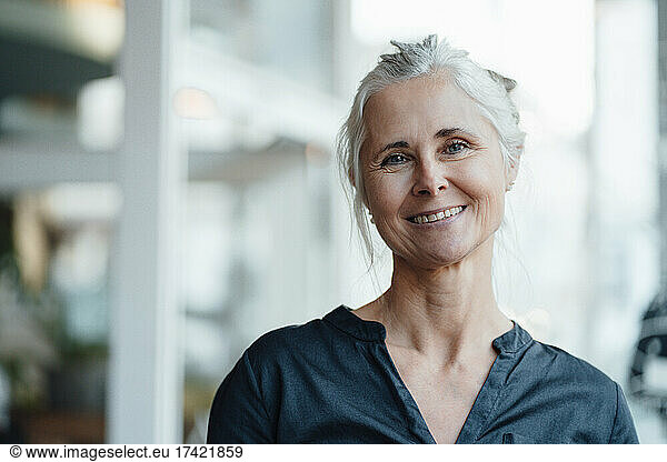 Smiling woman with gray hair in coffee shop