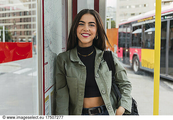 Smiling woman with jacket at bus stop