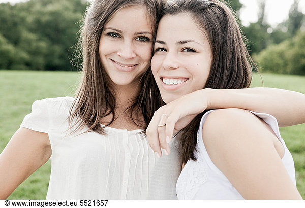 Smiling women hugging outdoors