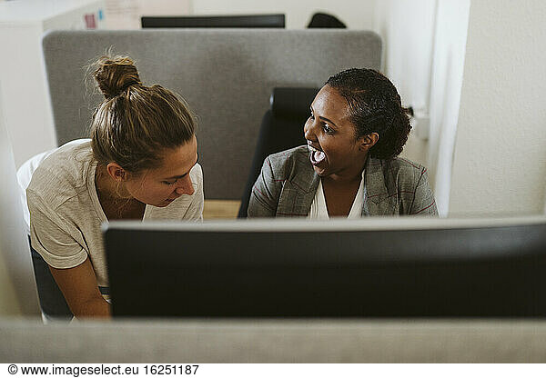Smiling women talking in office