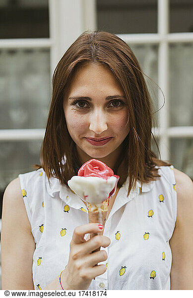Smiling young beautiful woman holding ice cream