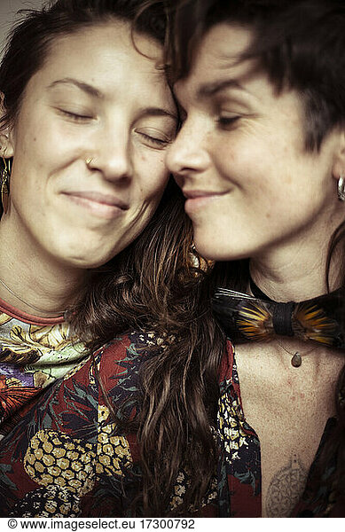 Smiling young beautiful women share a loving intimate moment