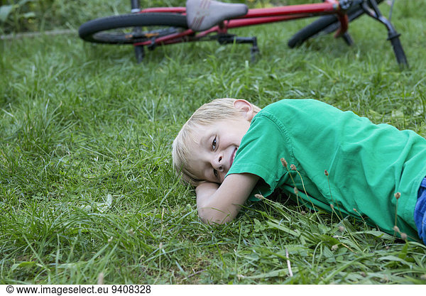 Smiling young boy lying on a meadow