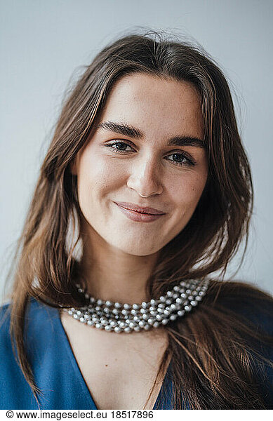 Smiling young businesswoman wearing silver necklace