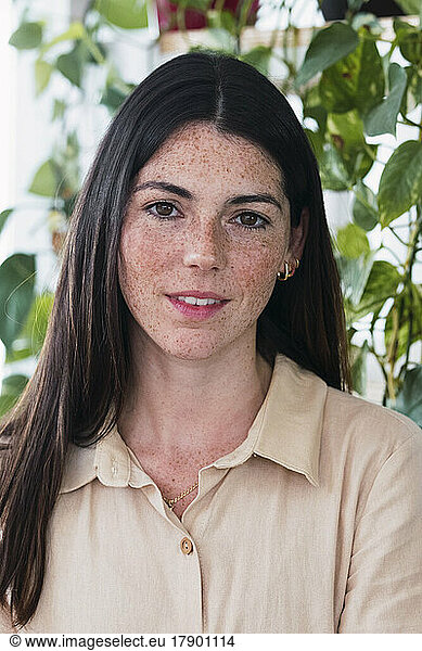 Smiling young businesswoman with freckles and long hair
