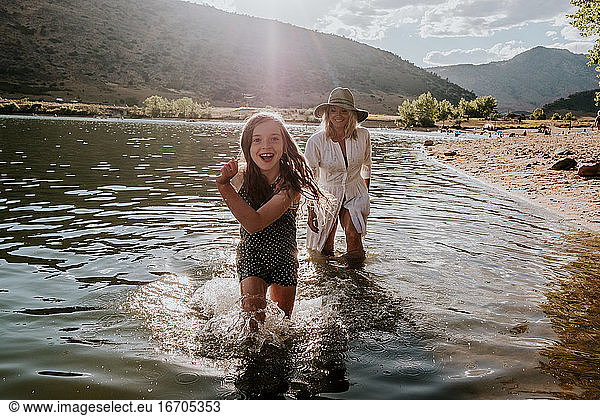Smiling young girl running through water on a sunny afternoon