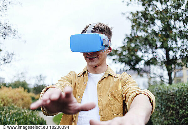 Smiling young man wearing virtual reality headset