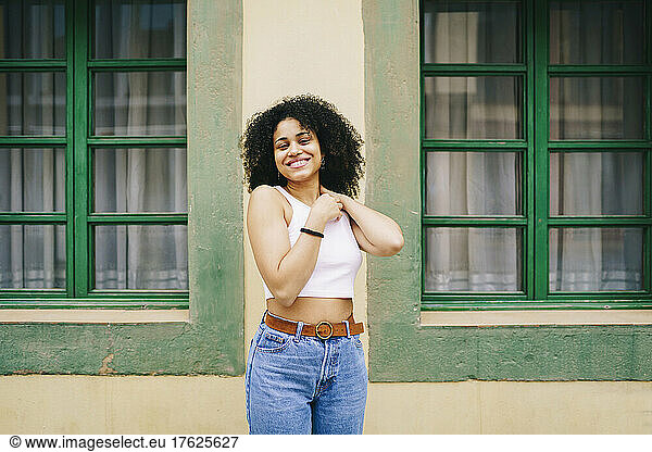 Smiling young woman in front of windows