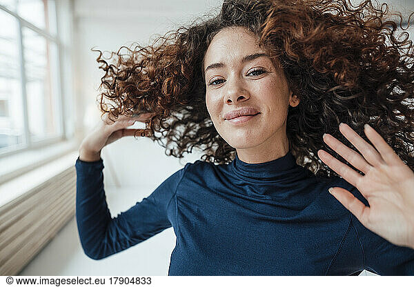 Smiling young woman tossing hair