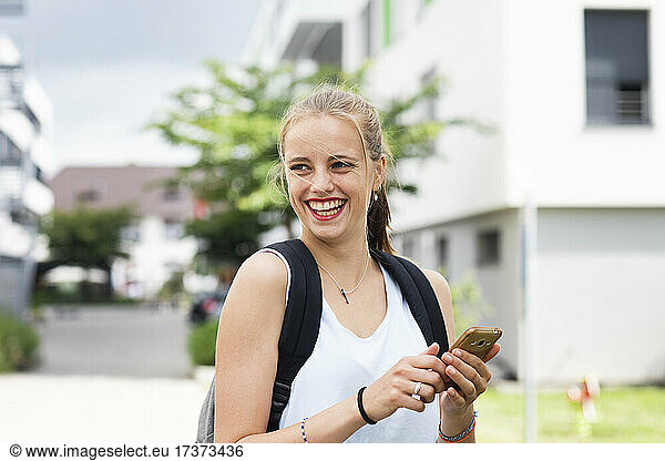 Smiling young woman using phone