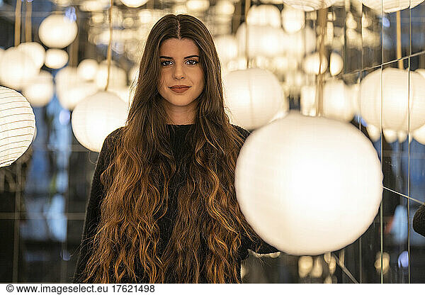 Smiling young woman with illuminated circular lanterns