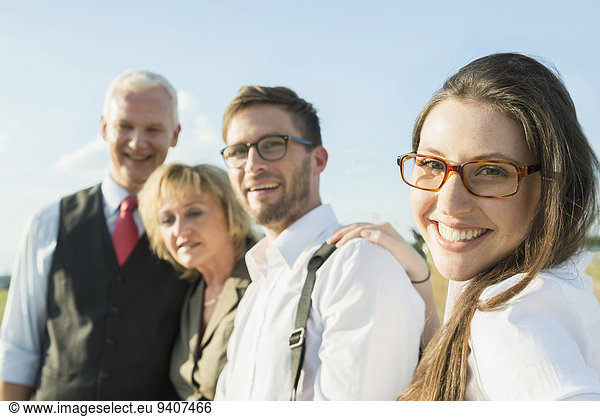 Smiling young woman with three other people outdoors portrait