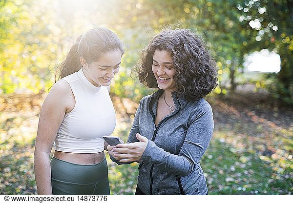 Smiling young women looking at cell phone