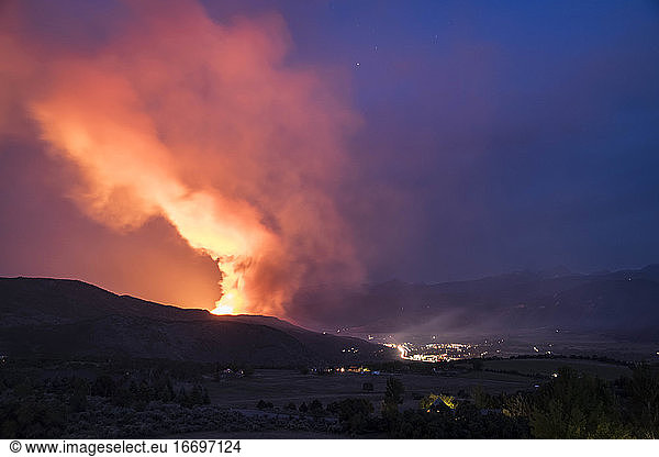 Smoke emitting from wildfire in forest at night