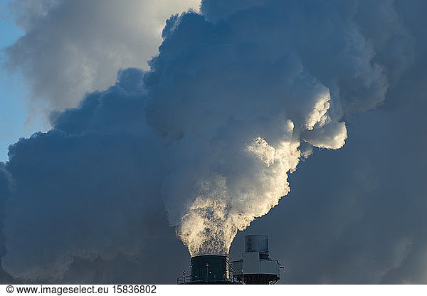 Smoke Stacks Pour Pollution Backlit by Sunrise