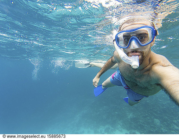 Snorkeler taking underwater selfie