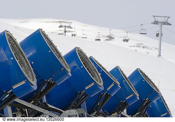 Snow canons standing in a row on the edge of a piste in front of a chair-lift  Graubuenden  Switzerland  Europe