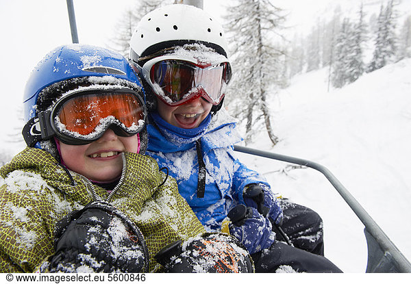 Snow-covered children in ski lift