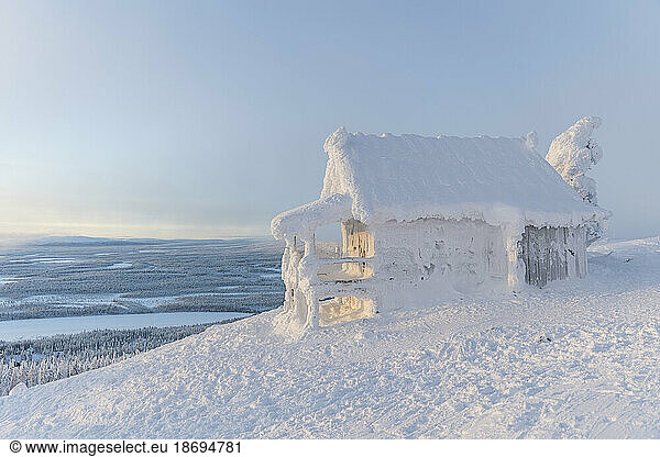 Snow-covered house in winter landscape