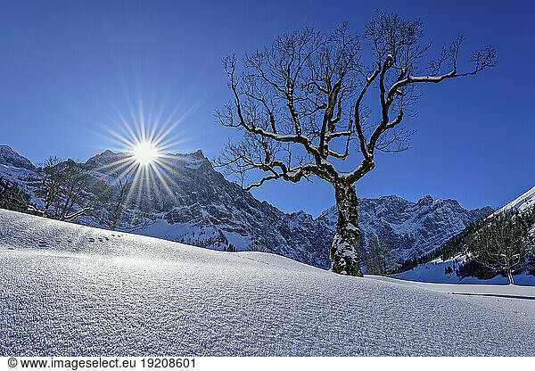Snow covered landscape by Karwendel Mountains on sunny day