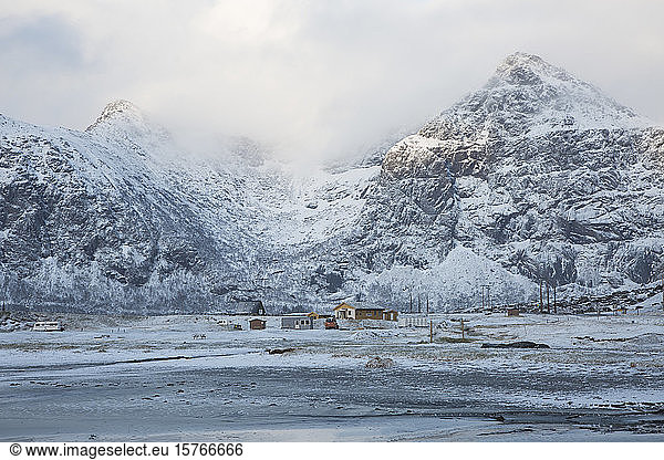 Snow covered mountains and remote cabins Flakstad Lofoten Norway