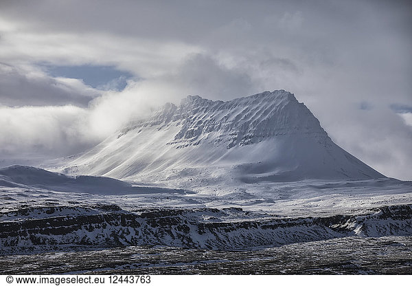 Snow covered peak behind the town of Djupavik  Djupavik  West Fjords  Iceland
