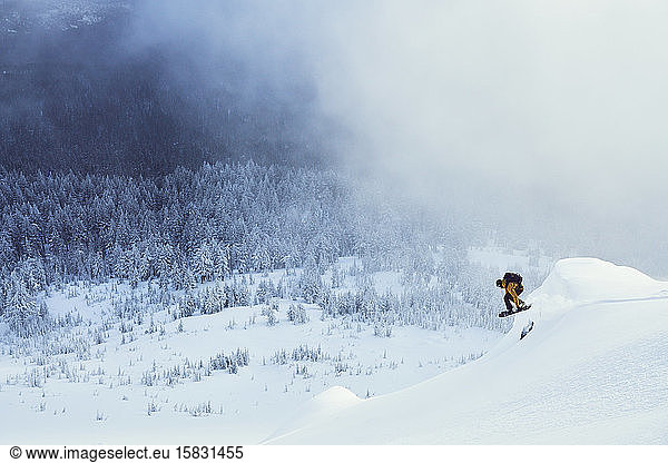 Snowboarder Jumping in Winter with Mist and Trees