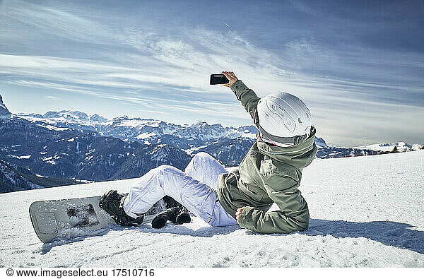 Snowboarding woman taking a selfie in the snow