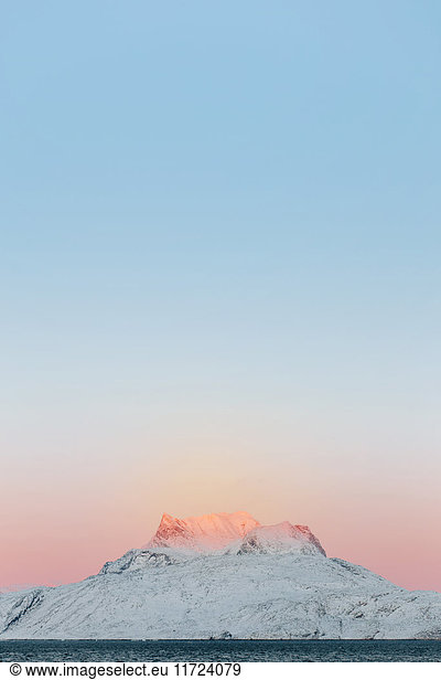 Snowcapped mountain against clear sky at sunset