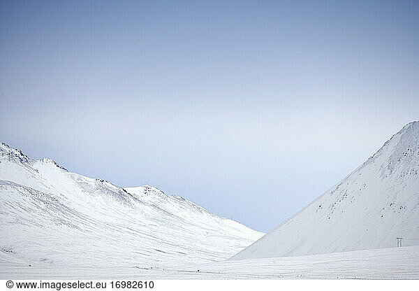 Snowy mountain slopes against blue sky