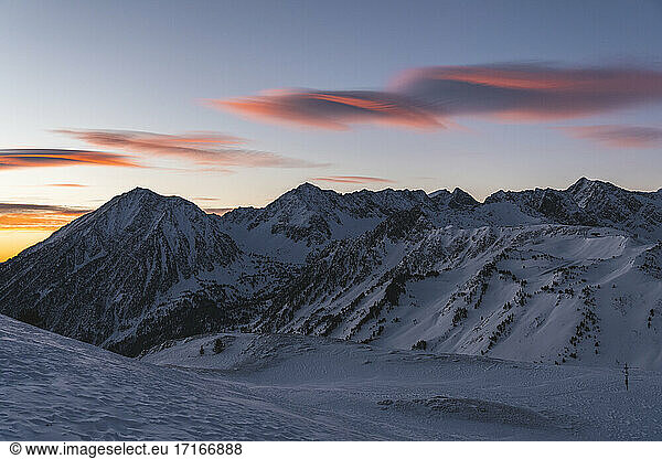 Snowy mountains against sky during sunrise
